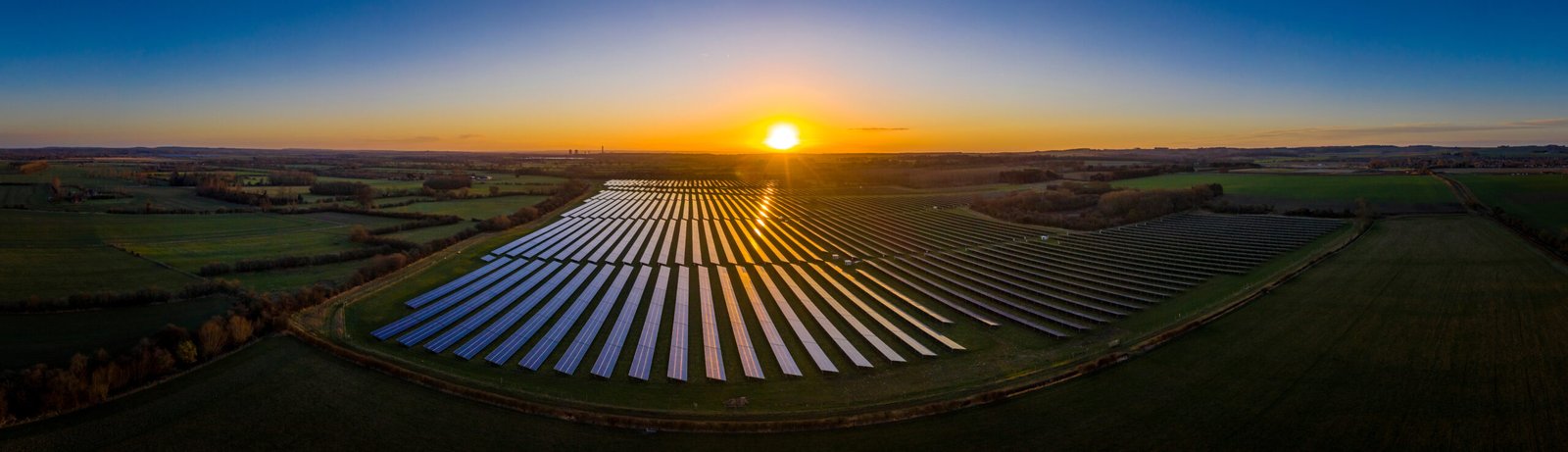 Panoramic of a solar farm at dawn taken from the air